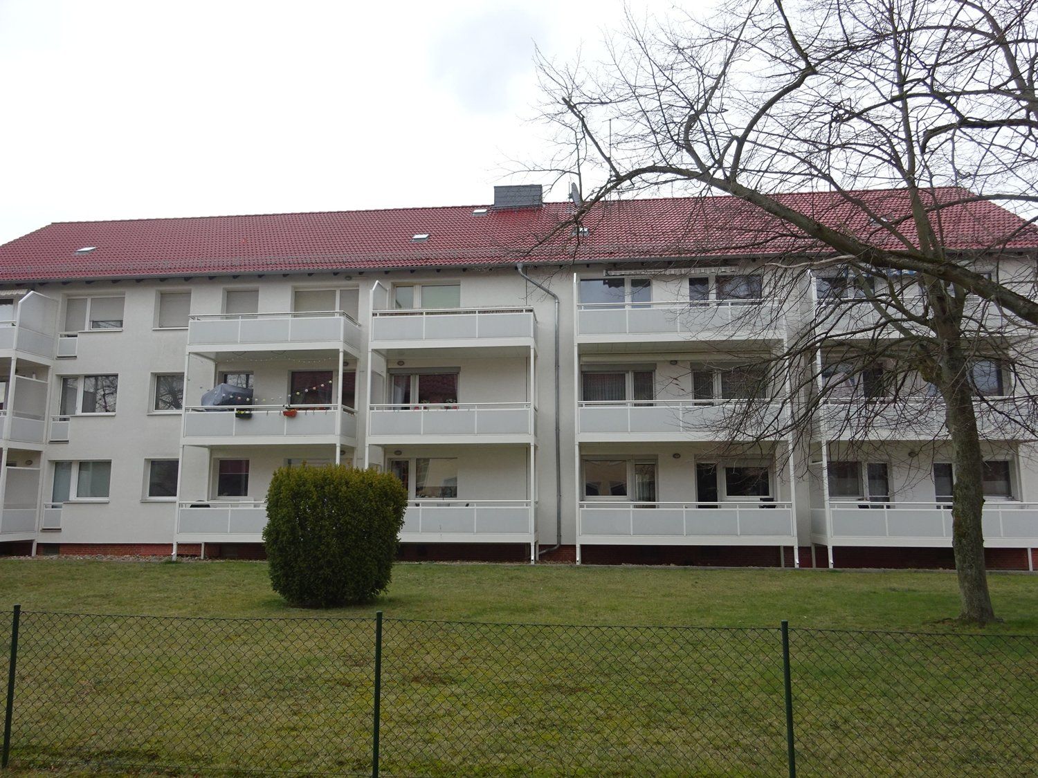 Ein großes weißes Wohnhaus mit einem roten Dach