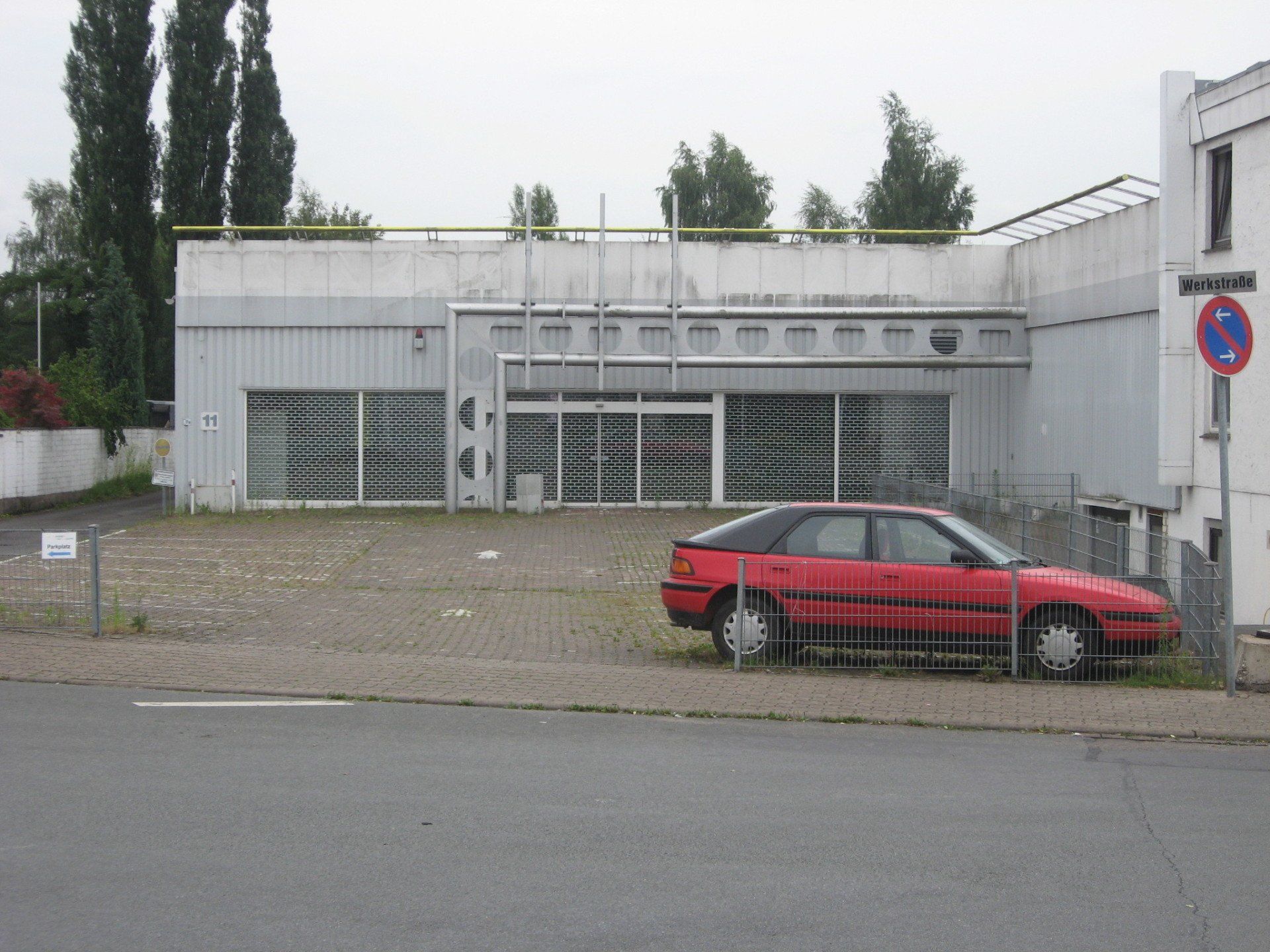 Ein rotes Auto steht vor einem weißen Gebäude