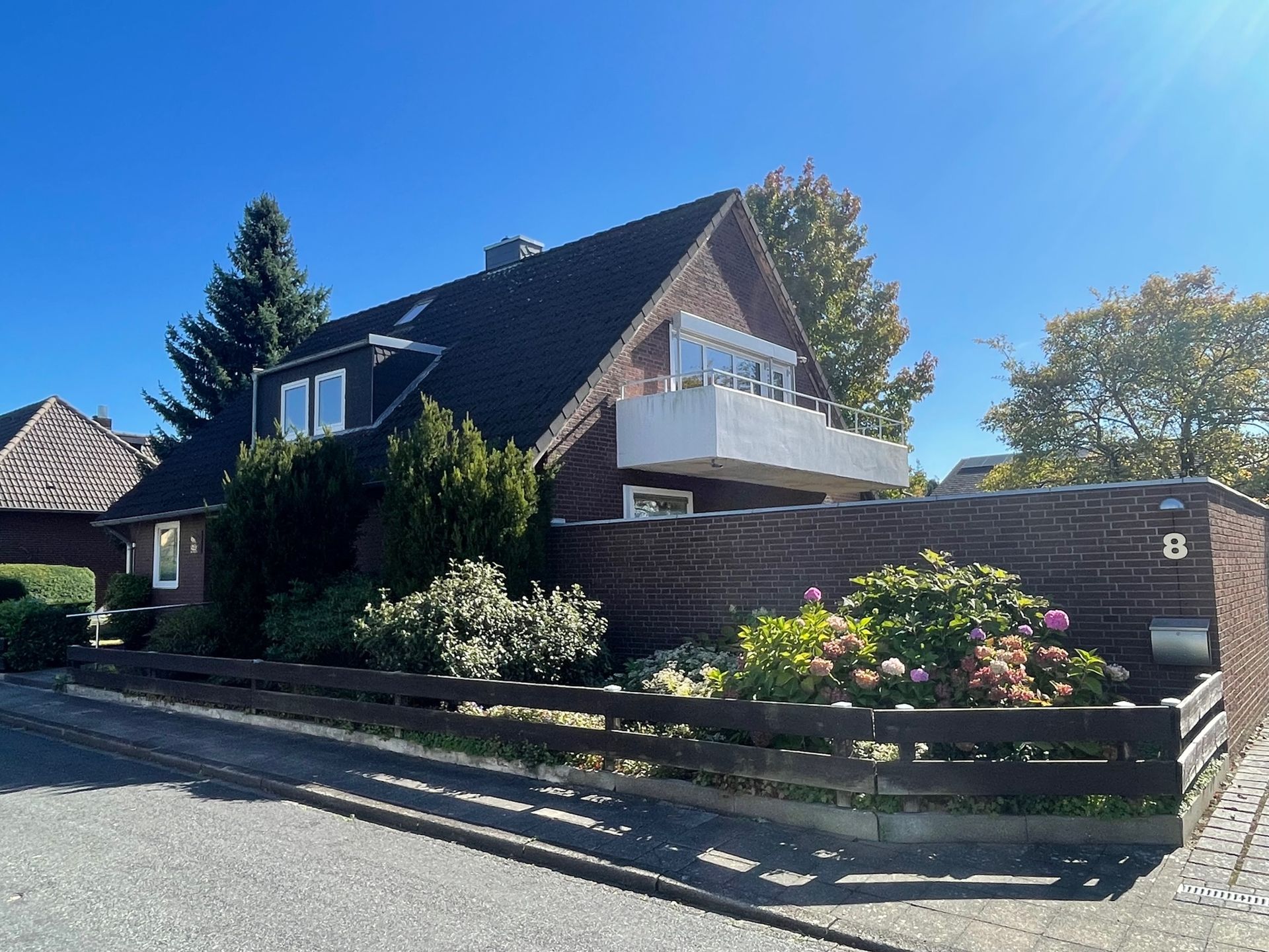 Eine künstlerische Darstellung eines großen weißen Wohnhauses