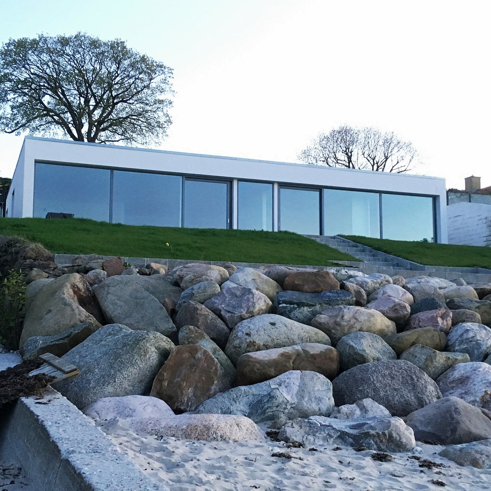 Ein großes Gebäude mit vielen Fenstern ist von Felsen umgeben