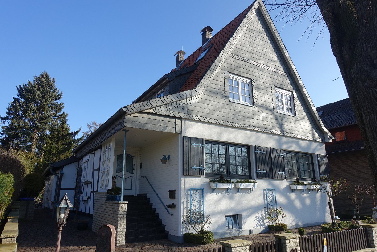 Ein großes weißes Haus mit einem roten Dach