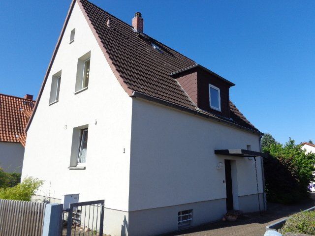 Ein großes weißes Haus mit einem braunen Dach