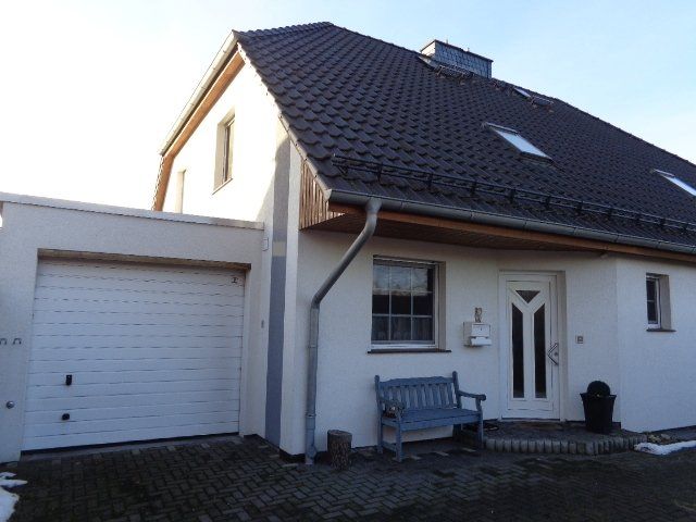 Ein weißes Haus mit einer blauen Bank davor