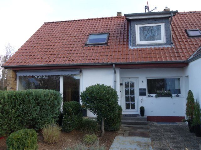 Ein weißes Haus mit einem roten Ziegeldach