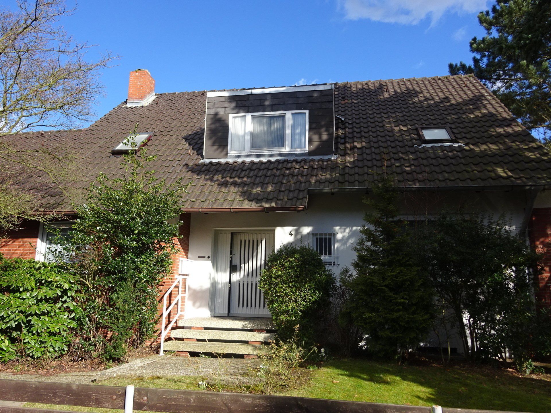 Ein Haus mit einem braunen Dach und einer weißen Tür
