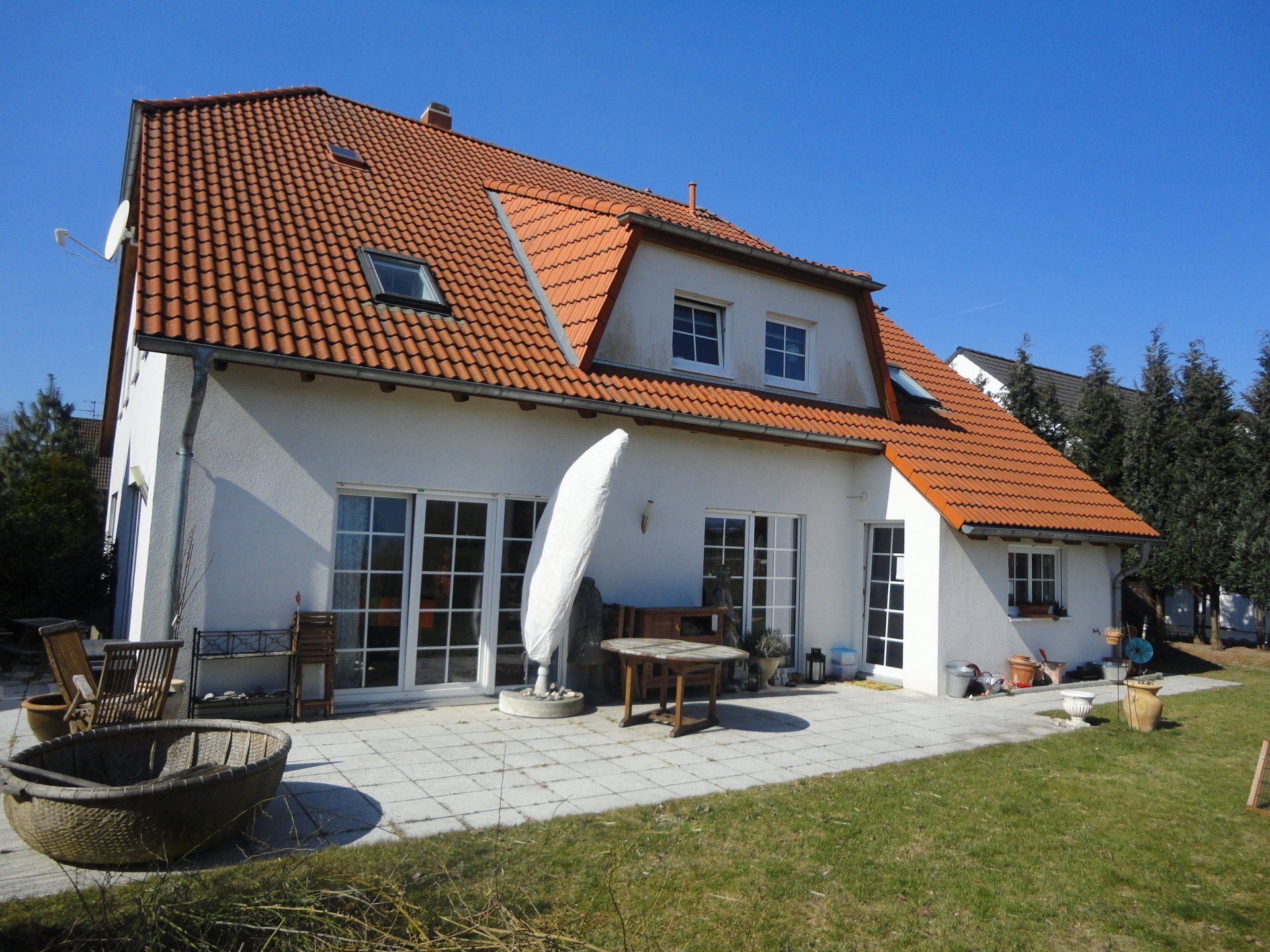 Ein großes weißes Haus mit einem roten Ziegeldach