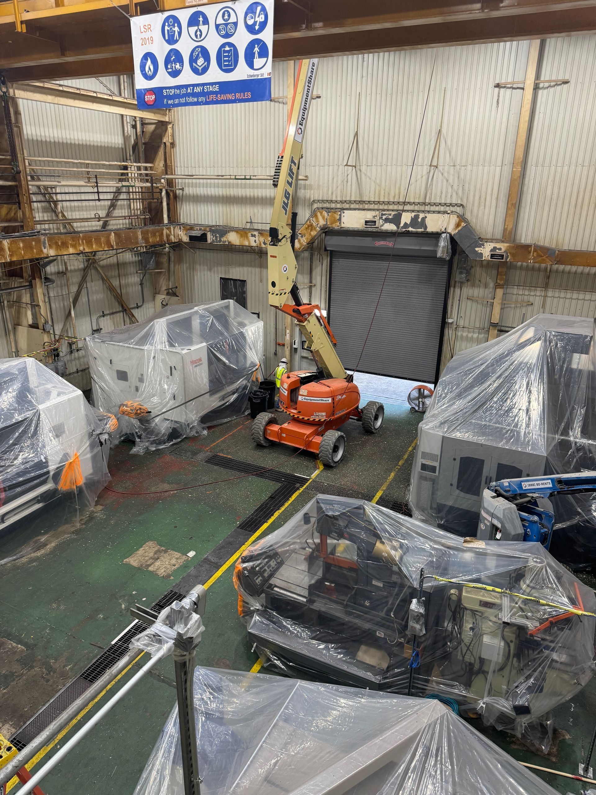 Bright sun over a commercial building rooftop with HVAC units and newly coated white surface. Blue sky.