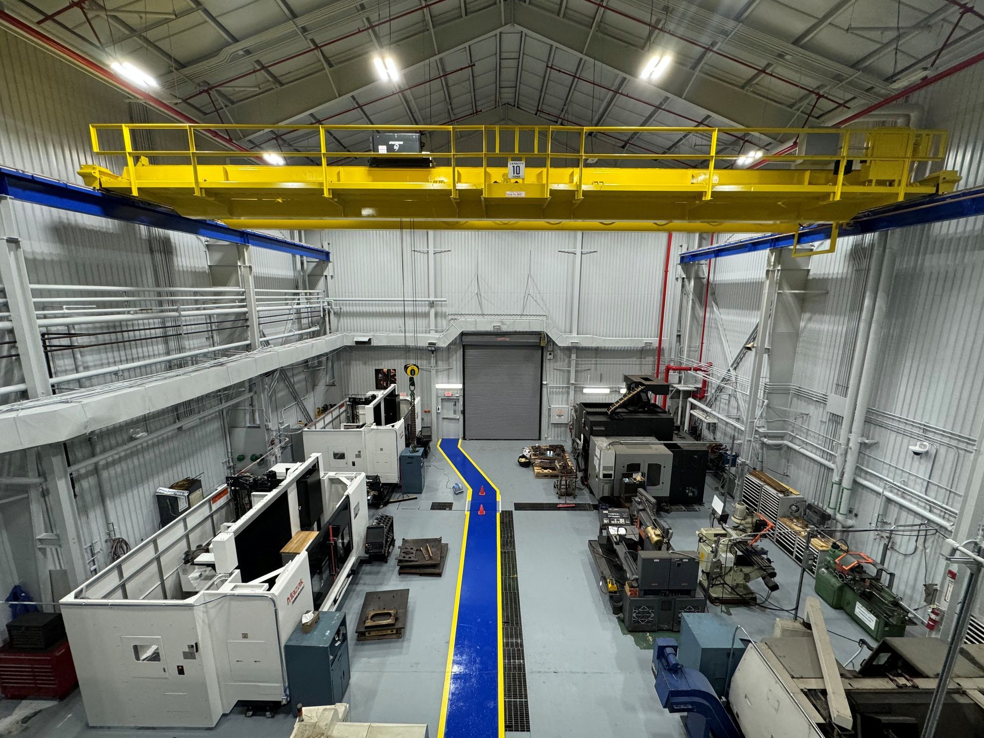 Rooftop view of a commercial building with HVAC units, a curved glass facade, and a cloudy sky.