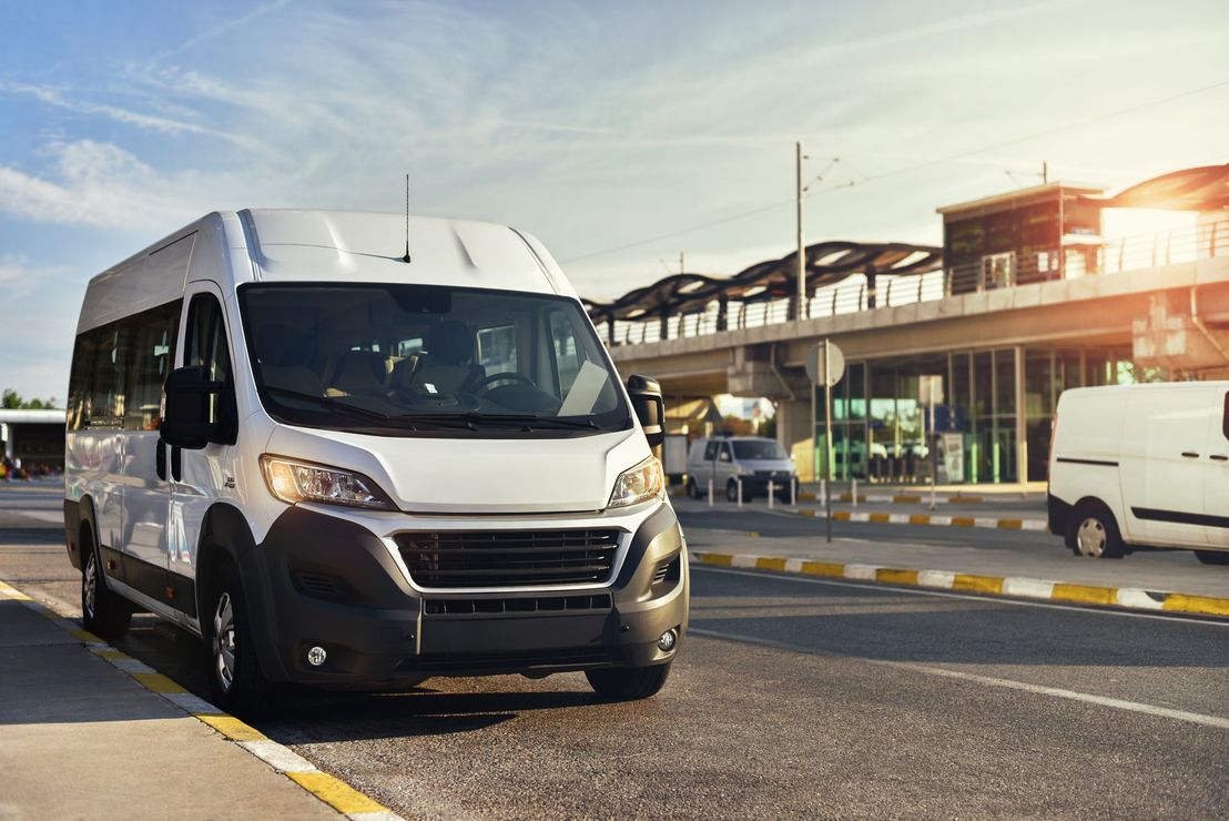 A white van is parked on the side of the road.