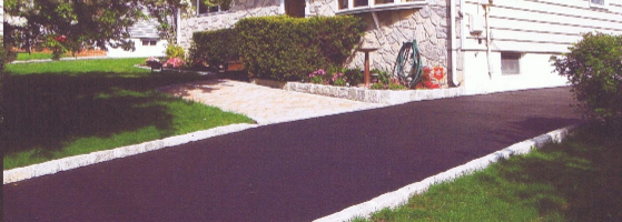 Asphalt sealcoating of a driveway.