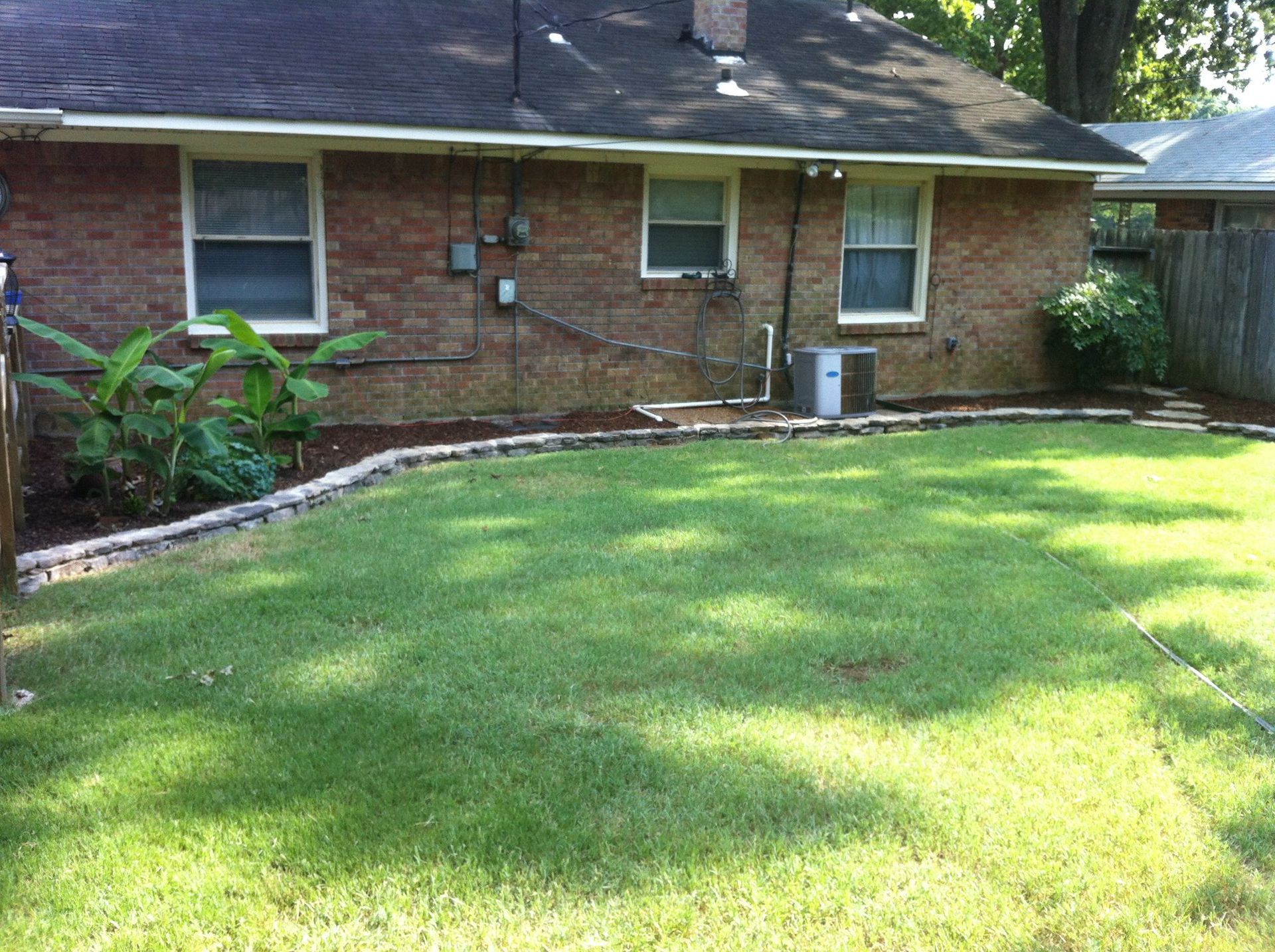 A brick house with a large lawn in front of it
