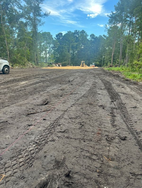A white truck is parked on the side of a dirt road.