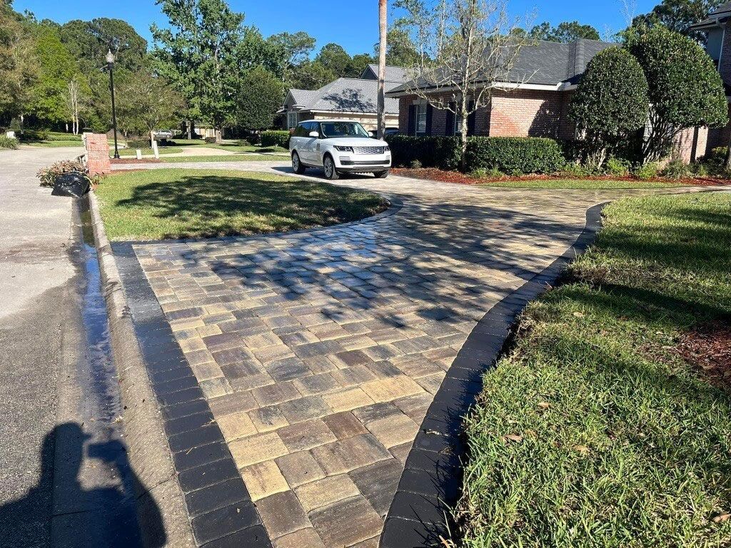 beige and brown paver driveway with black paver edging