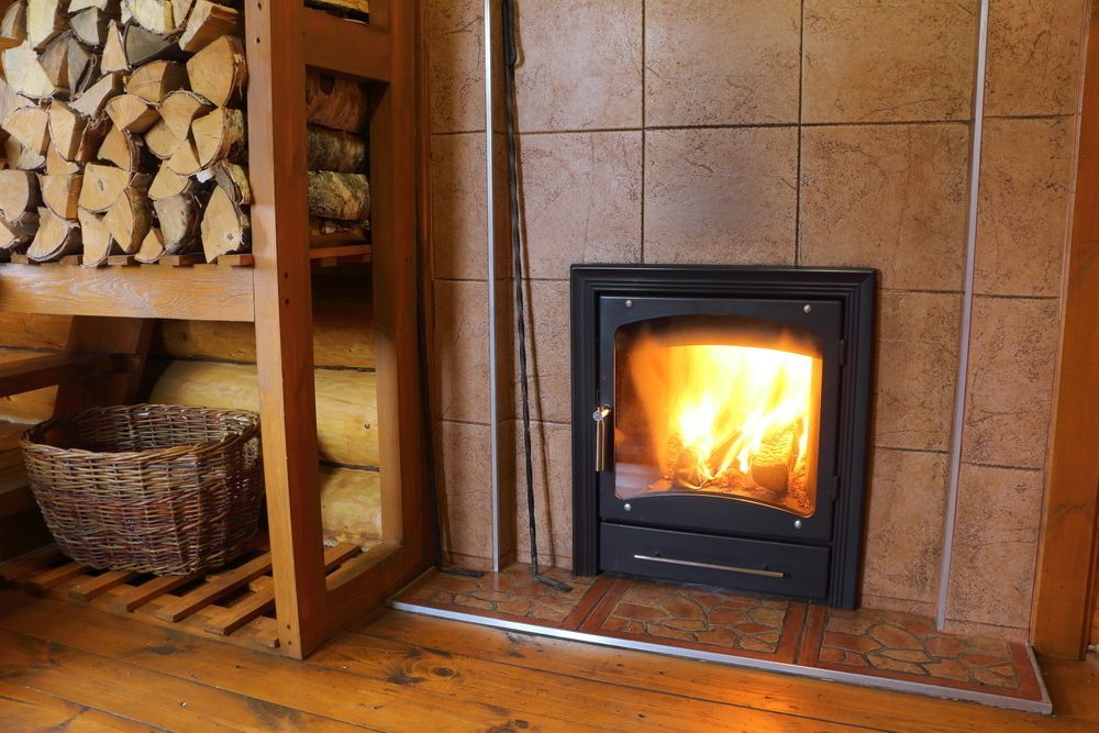 A Fireplace With A Basket Of Logs In The Background — PalmAir Heating & Cooling Specialists In Wagga Wagga, NSW