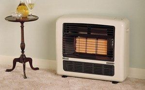 A Gas Heater Is Sitting Next To A Small Table In A Living Room — PalmAir Heating & Cooling Specialists In Tumut, NSW