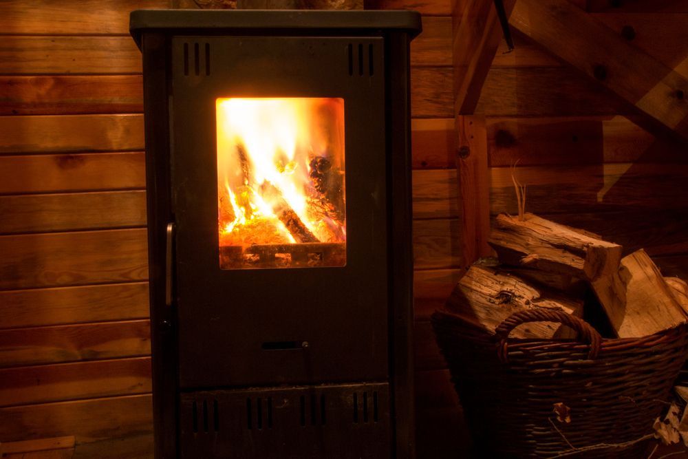 A Wood Stove Is Lit Up In A Wooden Cabin — PalmAir Heating & Cooling Specialists In Tumut, NSW