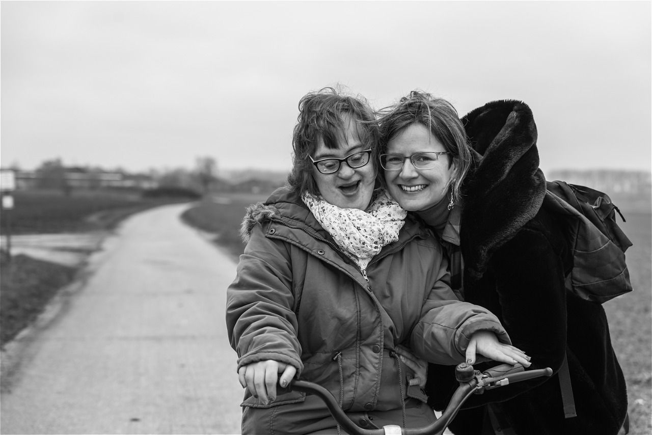 A kitchen with a long table and stools and a large island.