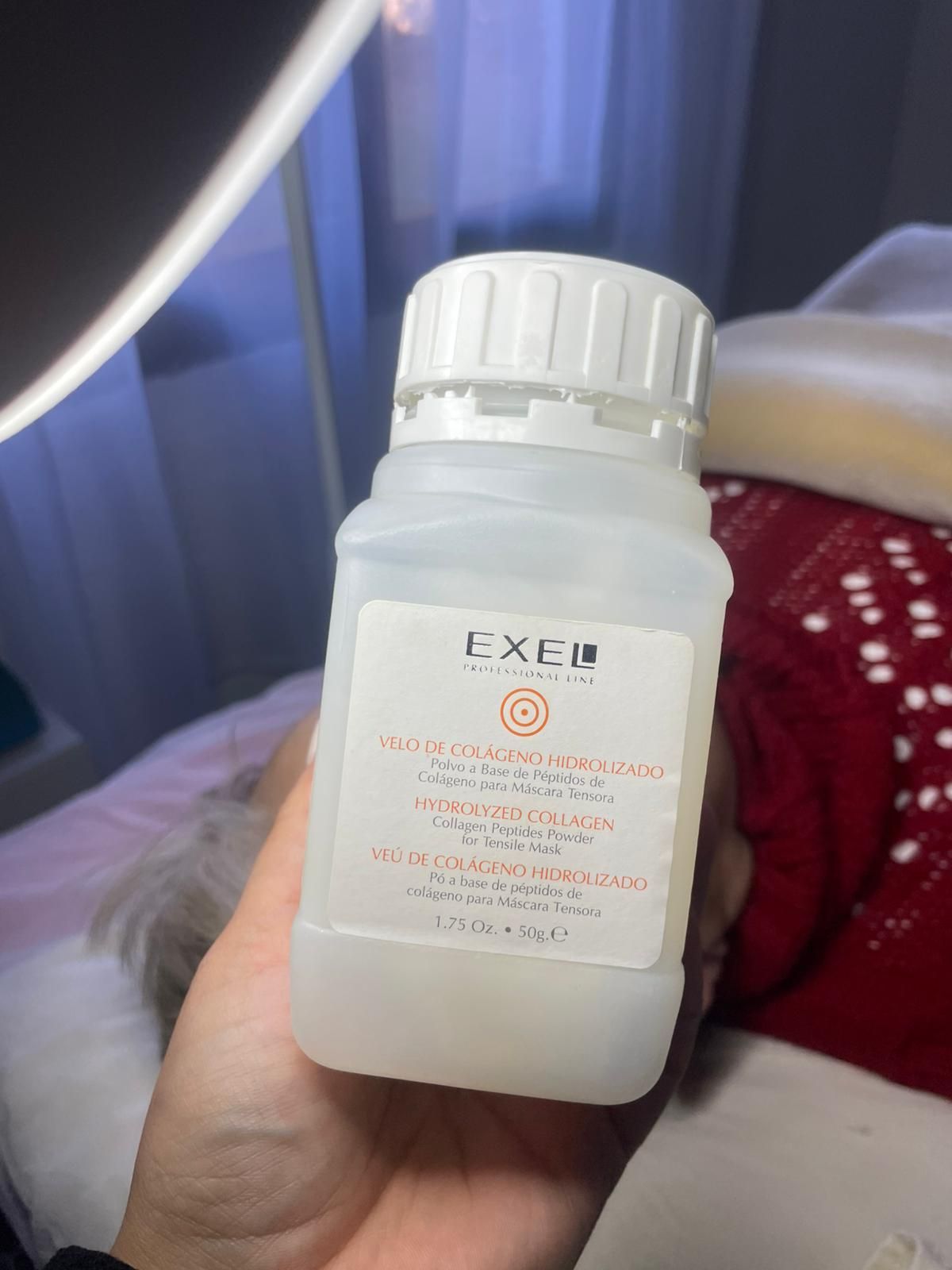 Persona sosteniendo una botella con una etiqueta naranja. La etiqueta dice