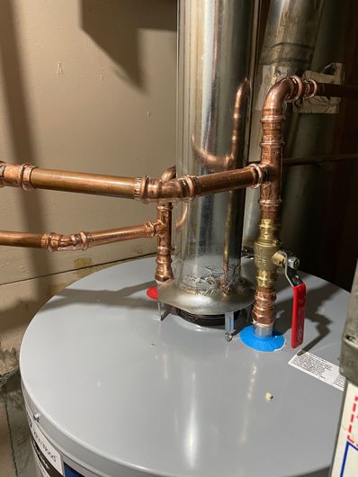 The water and venting connections on top of a traditional water tank heater