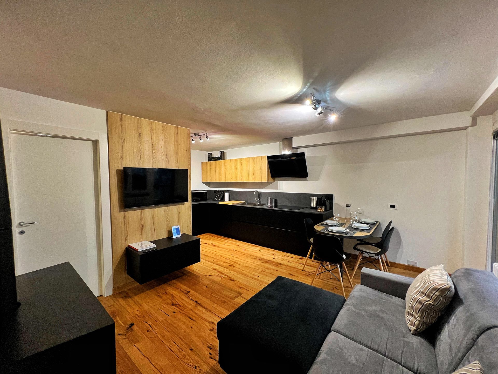 Un soggiorno con divano e tv a schermo piatto.