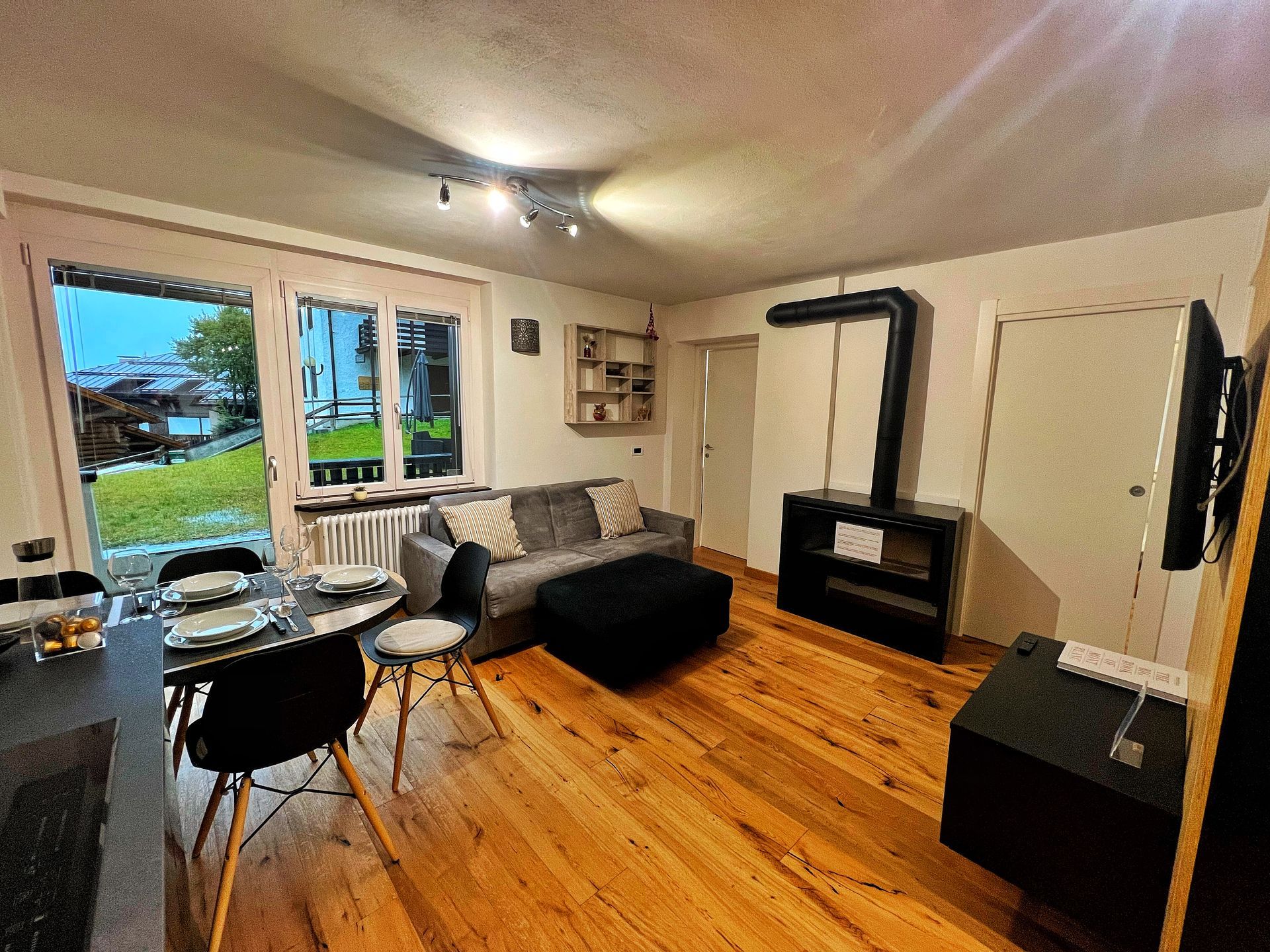 Un soggiorno con divano, tavolo, sedie e televisione.