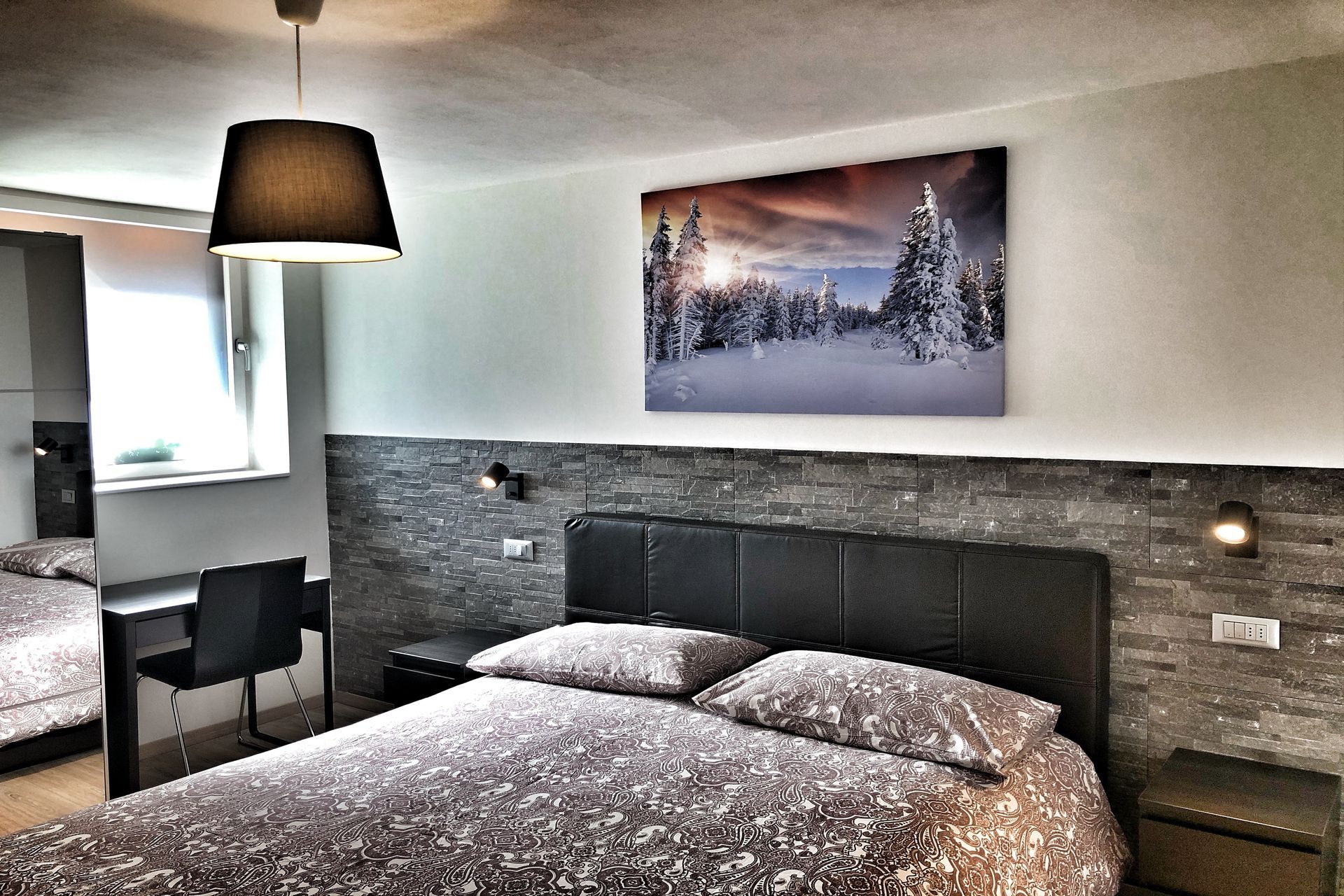 Una camera da letto con un dipinto sul muro sopra il letto