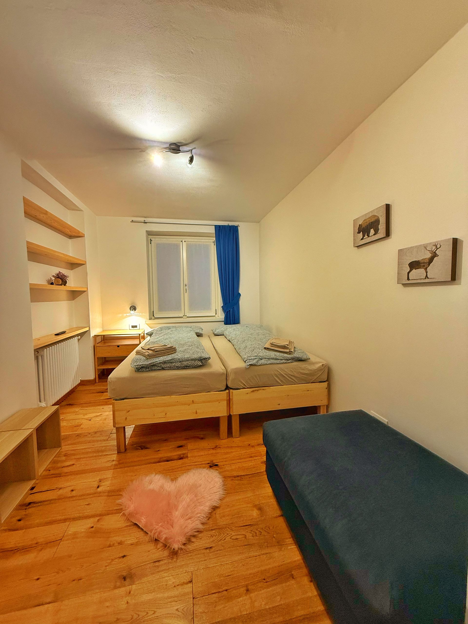 Una camera da letto con due letti e un cuore sul pavimento.