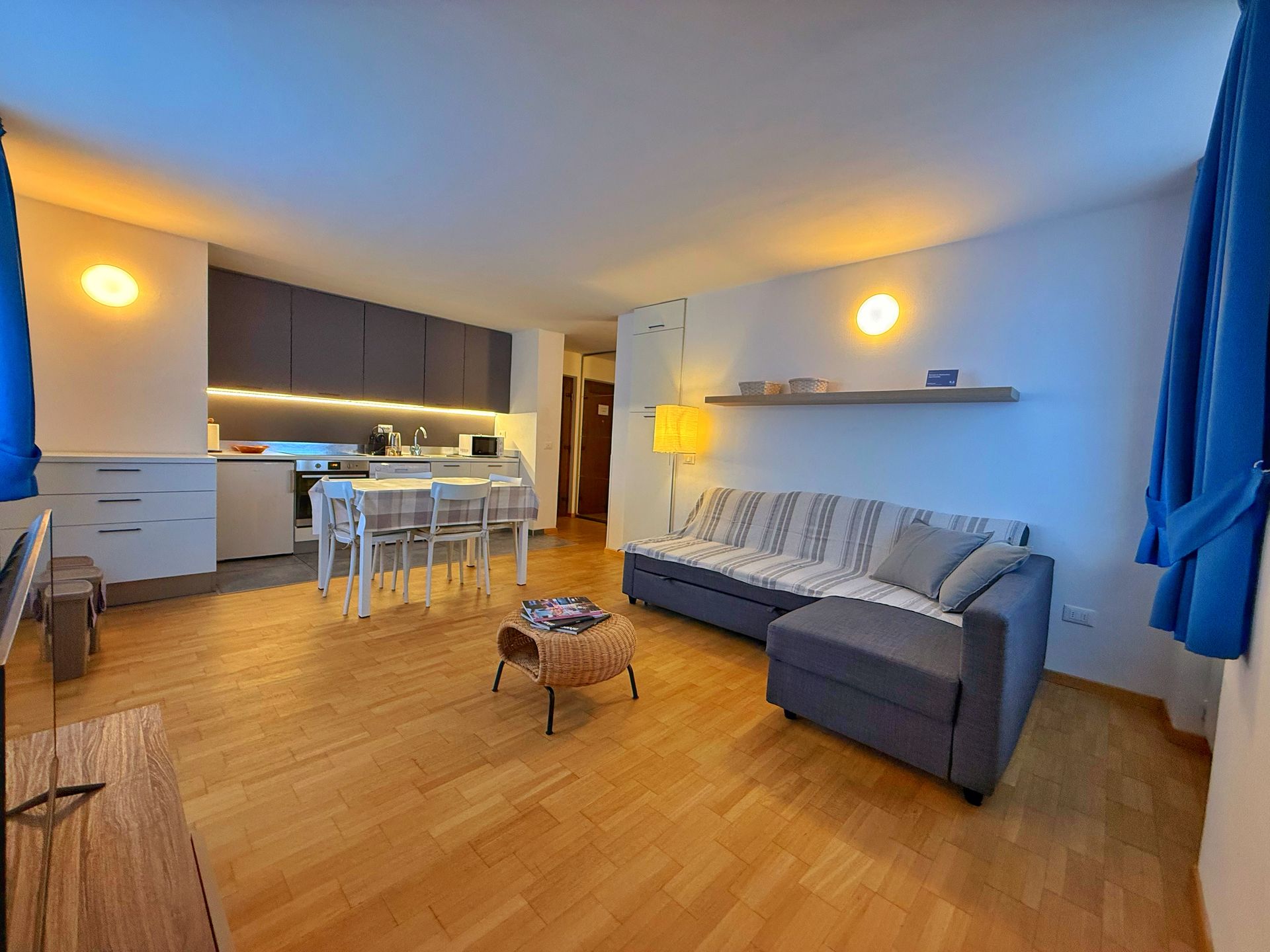 Un soggiorno con divano, sedia, tavolo e televisione.