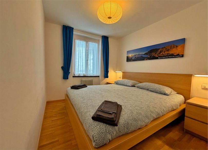 Una camera da letto con un letto grande e un quadro sulla parete soprastante