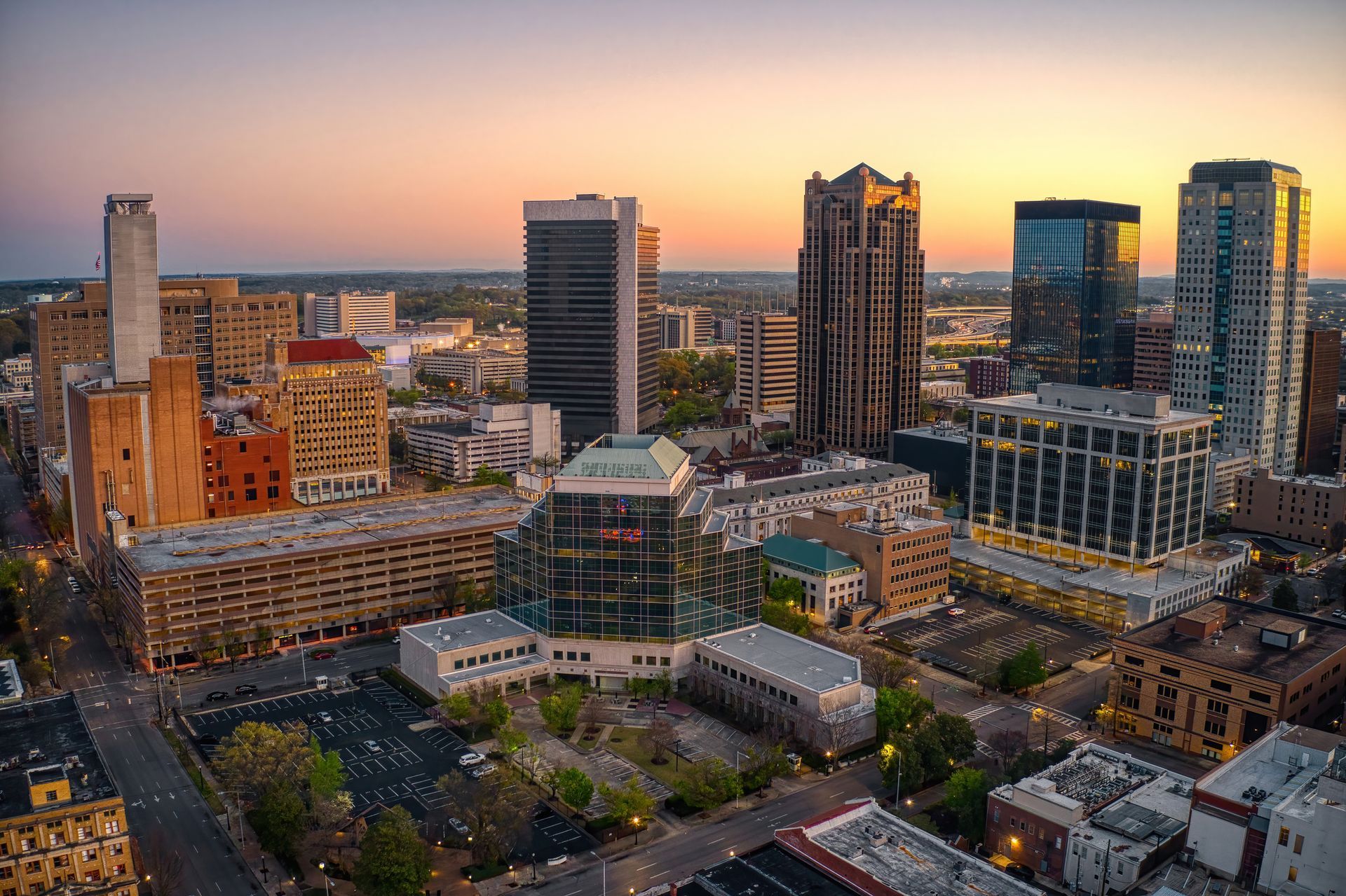 City skyline at sunset, with tall buildings, reflecting the golden hour.