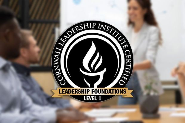 A group of people are sitting at a table in front of a cornwall leadership institute logo.