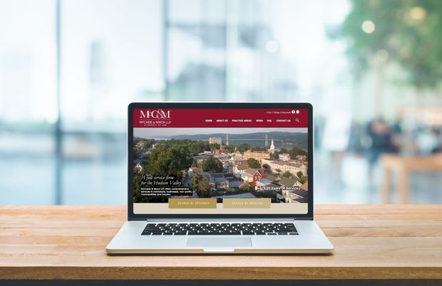 A laptop is sitting on a wooden table with a website on the screen.