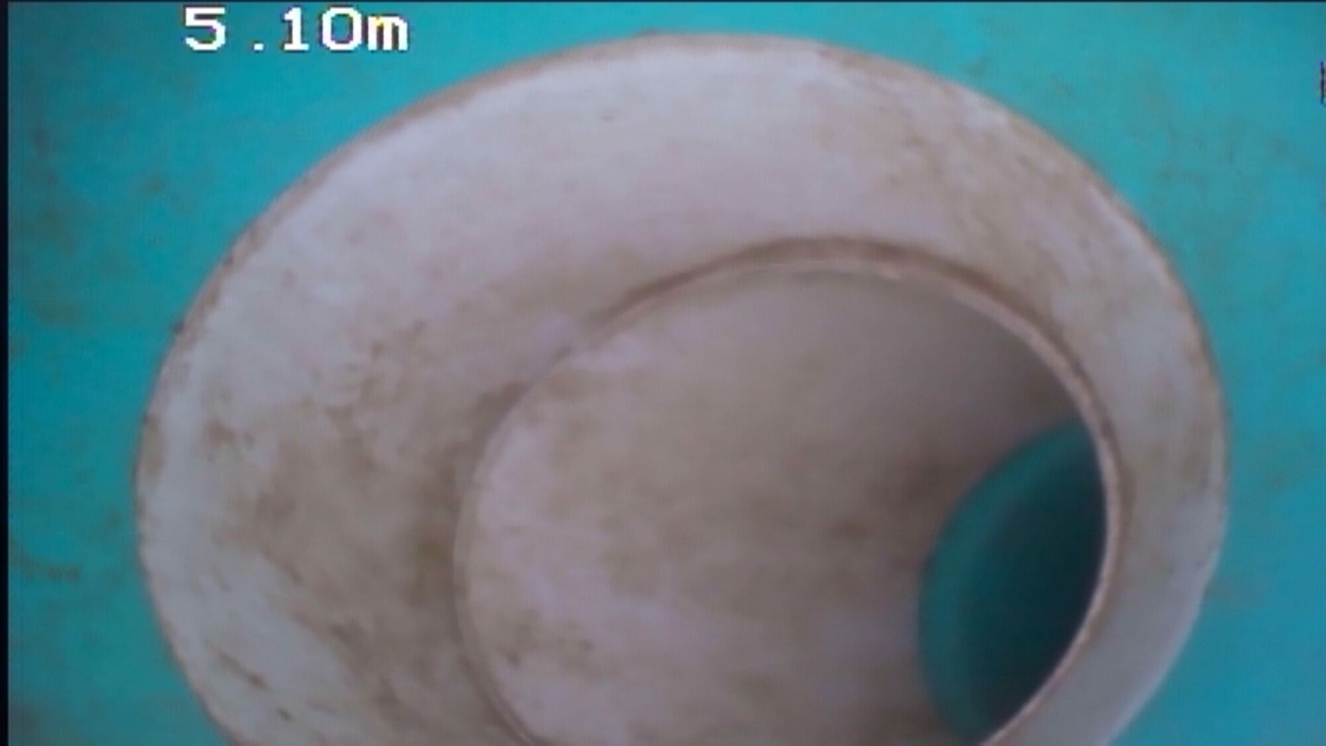 A close up of a white object with a hole in the middle on a blue surface.