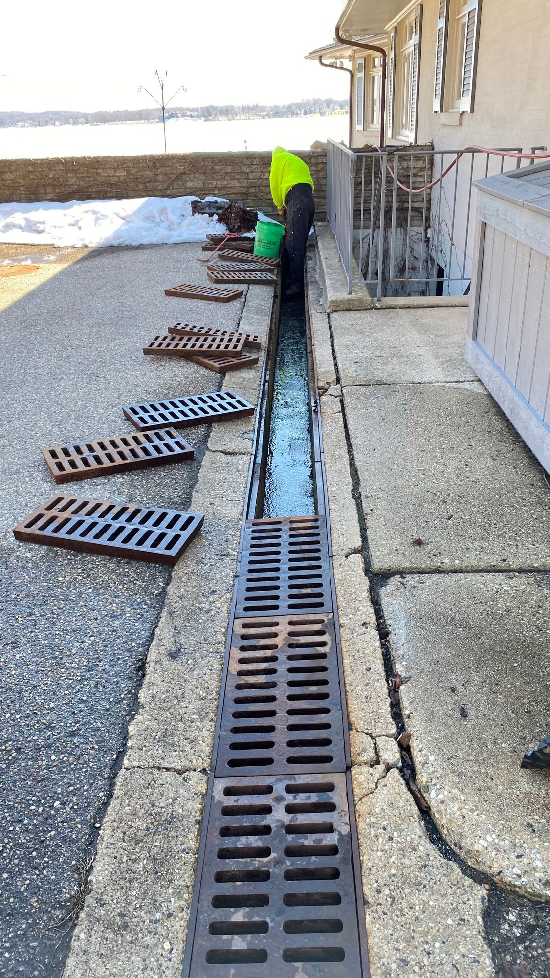 A manhole cover is sitting on the sidewalk next to a building.