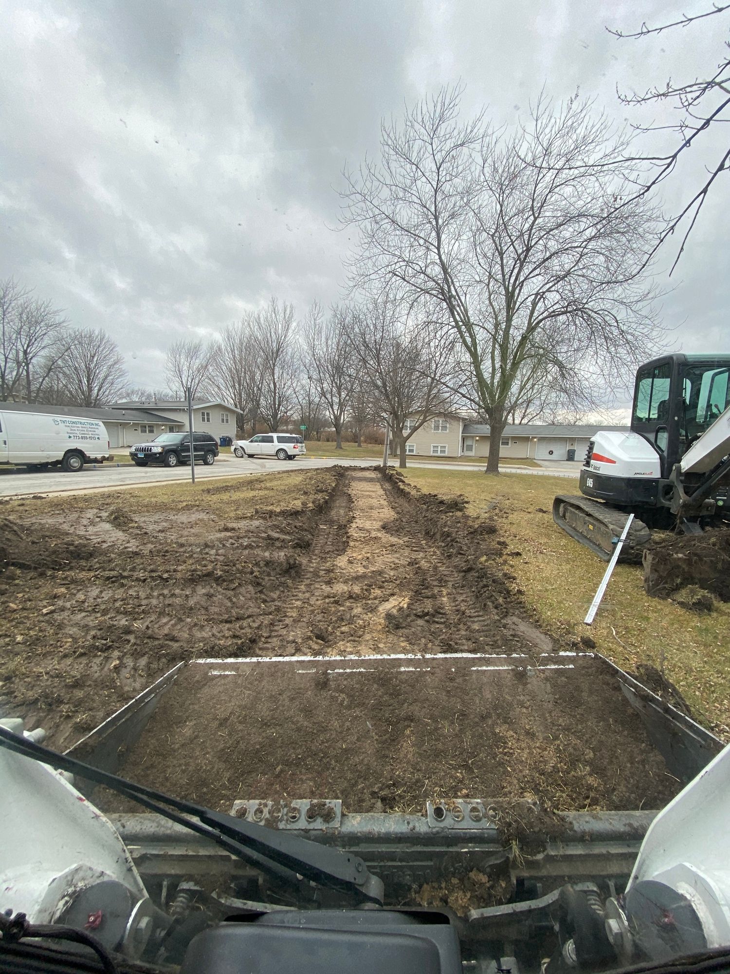 A person is driving a bulldozer on a dirt road.