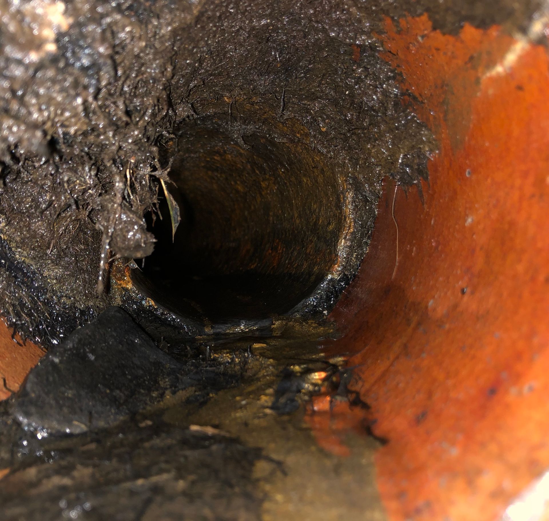A close up of a dirty pipe with water coming out of it