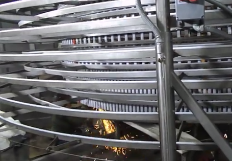 A close up of a spiral conveyor belt in a factory – USA - Regal Construction Inc.