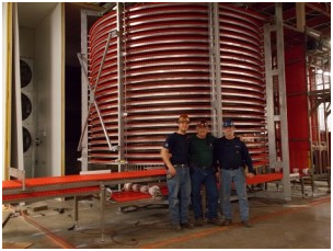 Three men standing in front of a red spiral staircase – USA - Regal Construction Inc.
