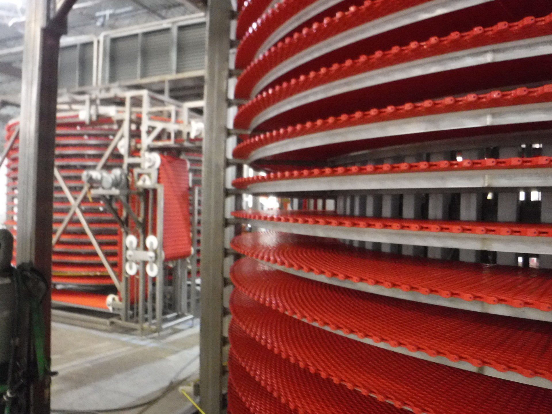 A red spiral conveyor belt is in a factory – USA - Regal Construction Inc.