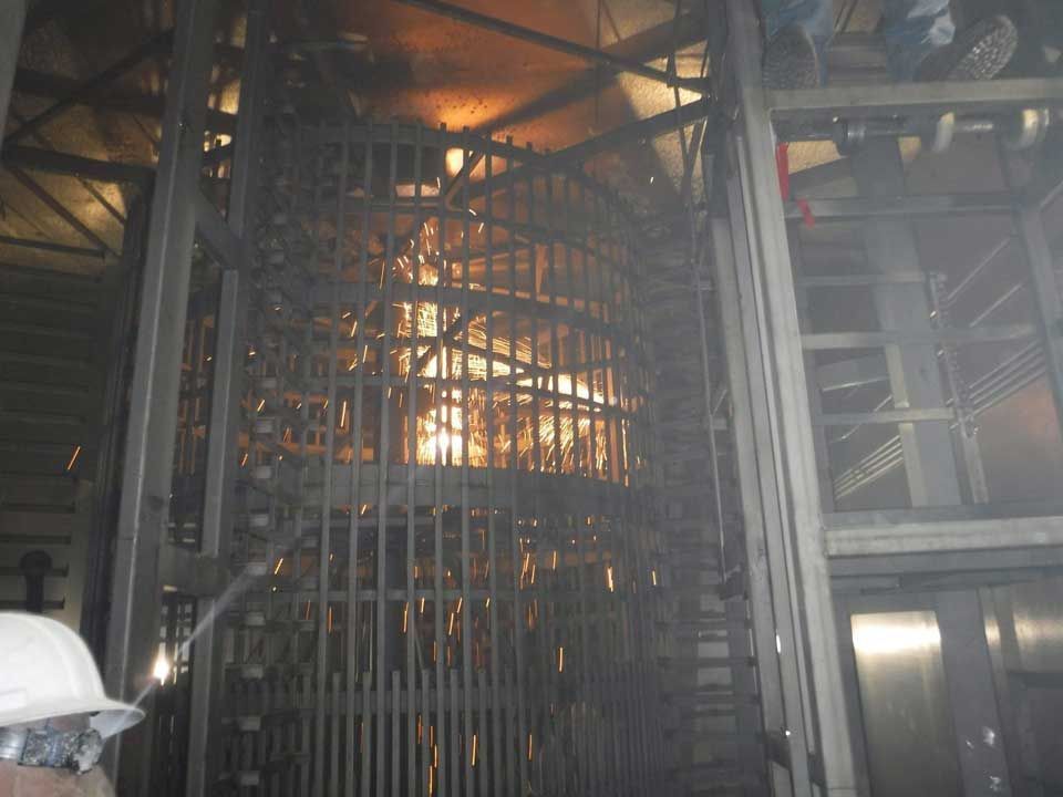 A man in a hard hat stands in front of a spiral staircase – USA - Regal Construction Inc.