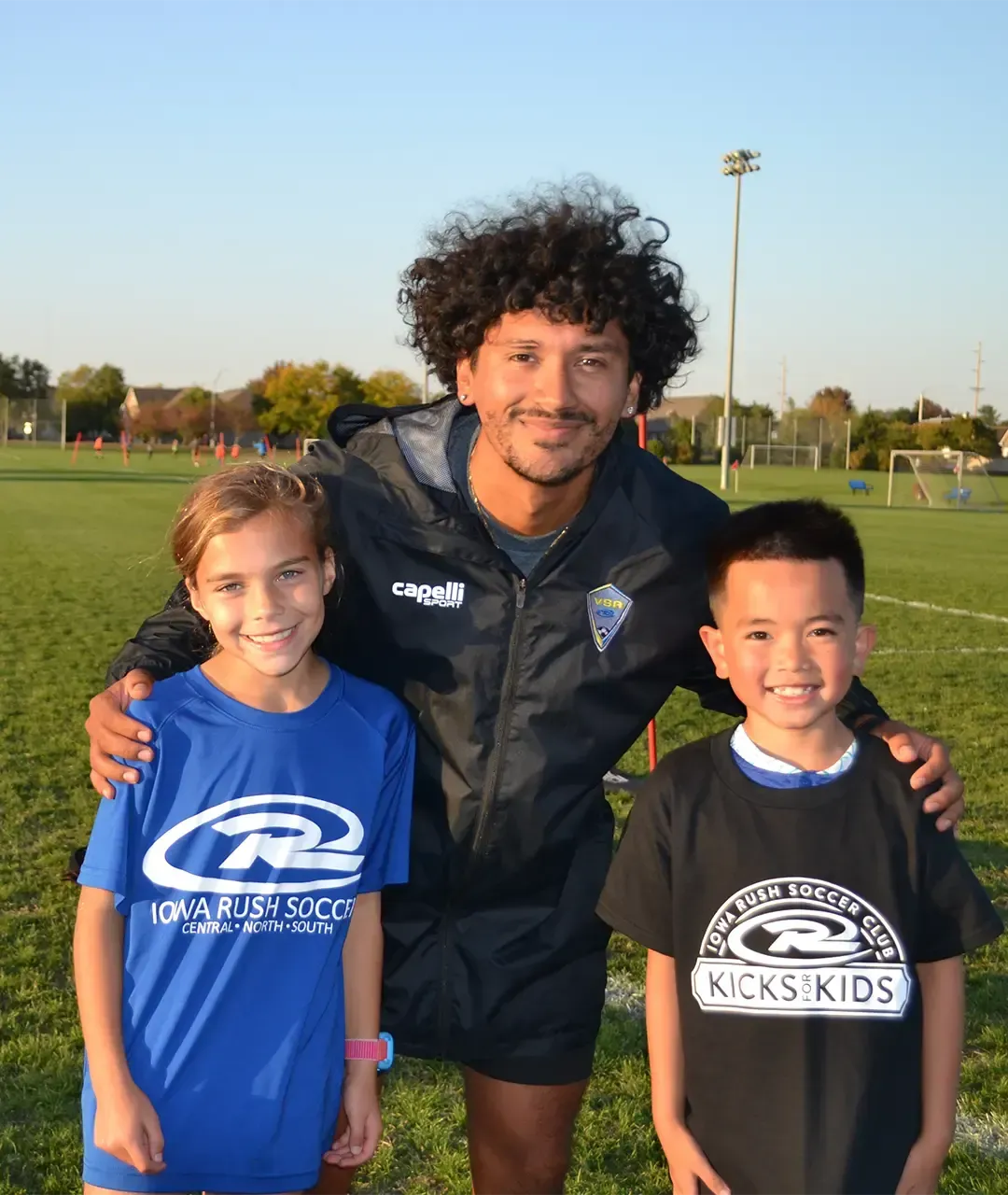 volunteer soccer coach huging players