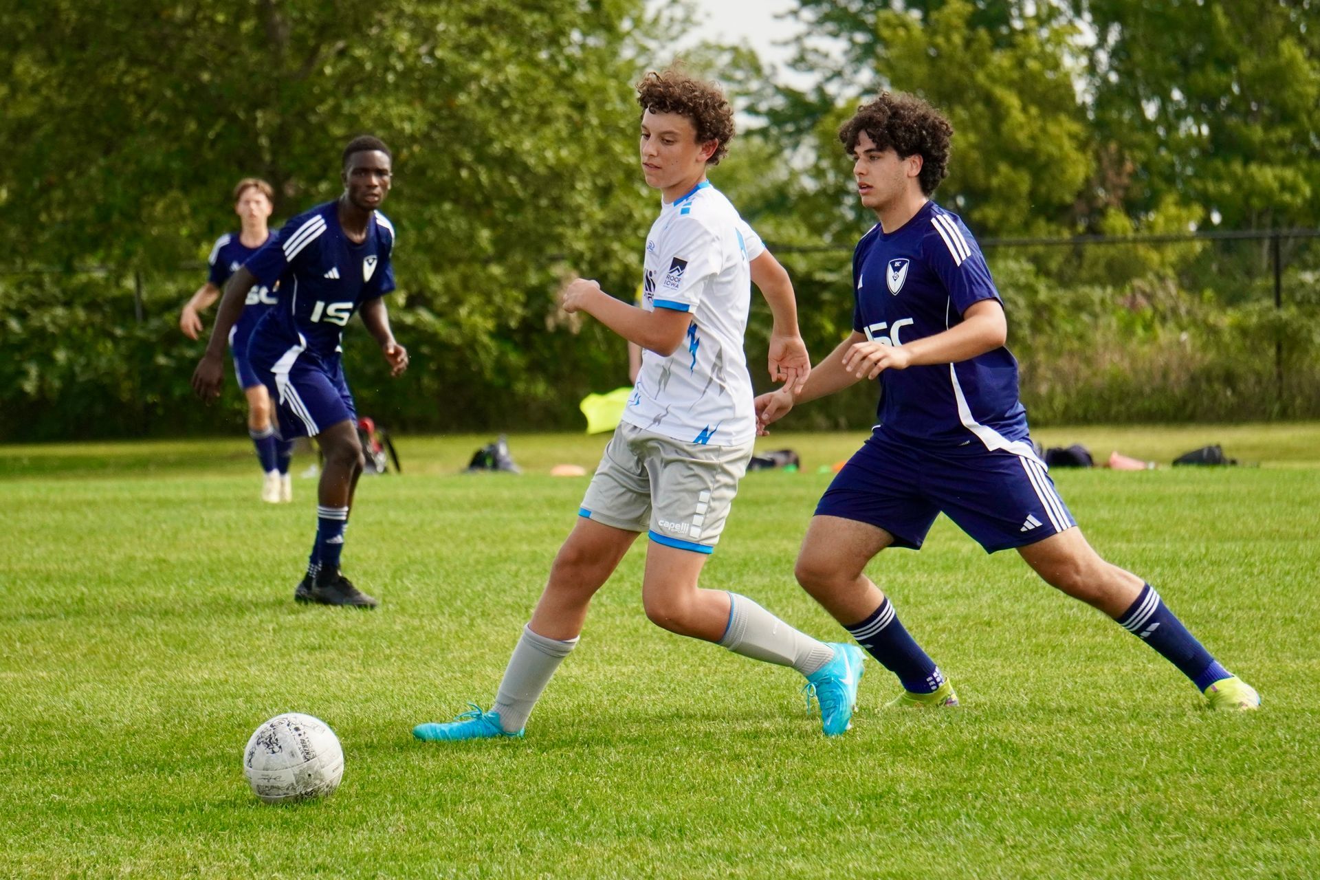 a boy soccer player kicking a soccer ball