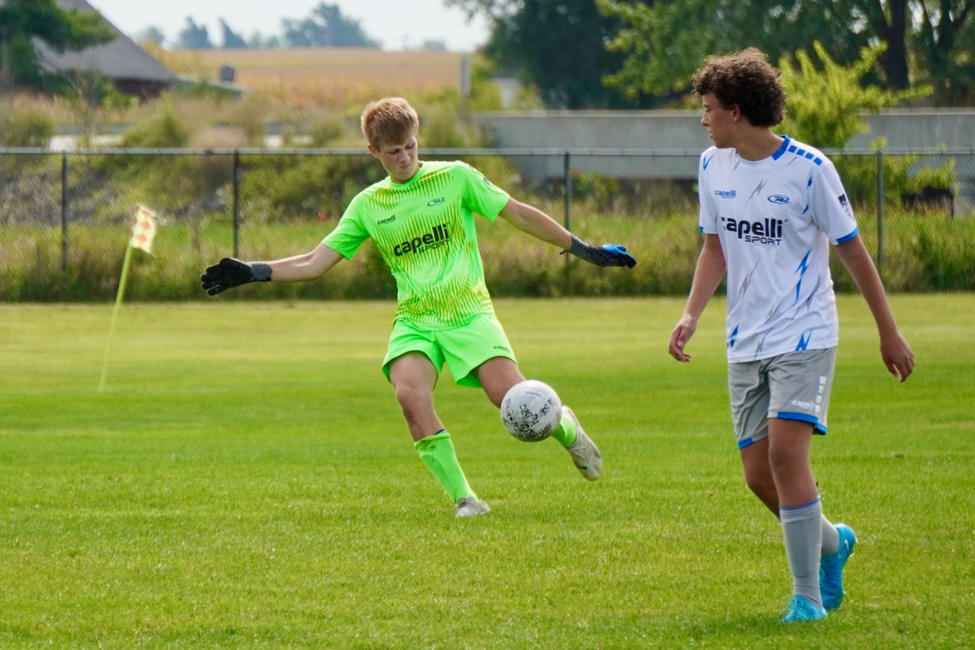 Two young men are playing soccer on a field.