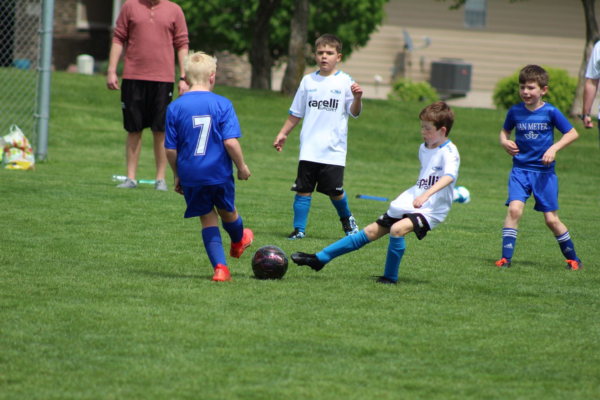 A group of young boys are playing soccer on a field.