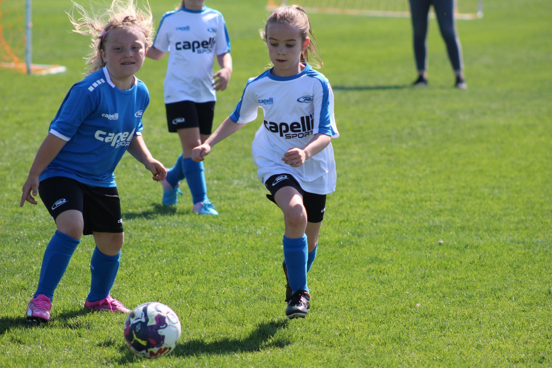 young girls playing soccer in Rush uniforms