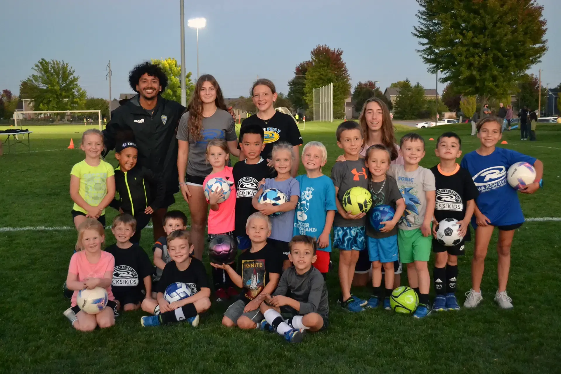 a crowd of soccer players with their hands in the air happy