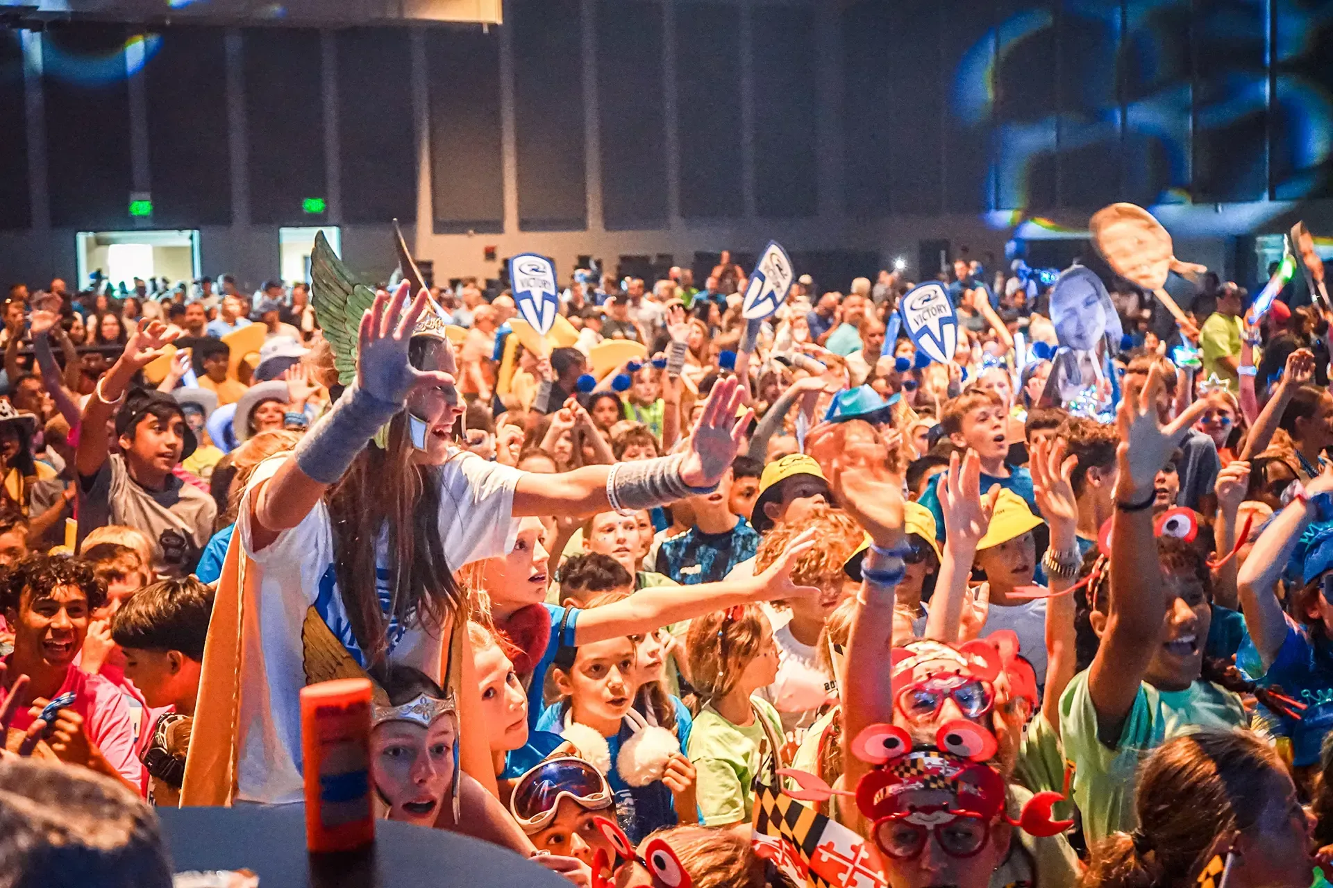 a crowd of kids with their hands in the air happy