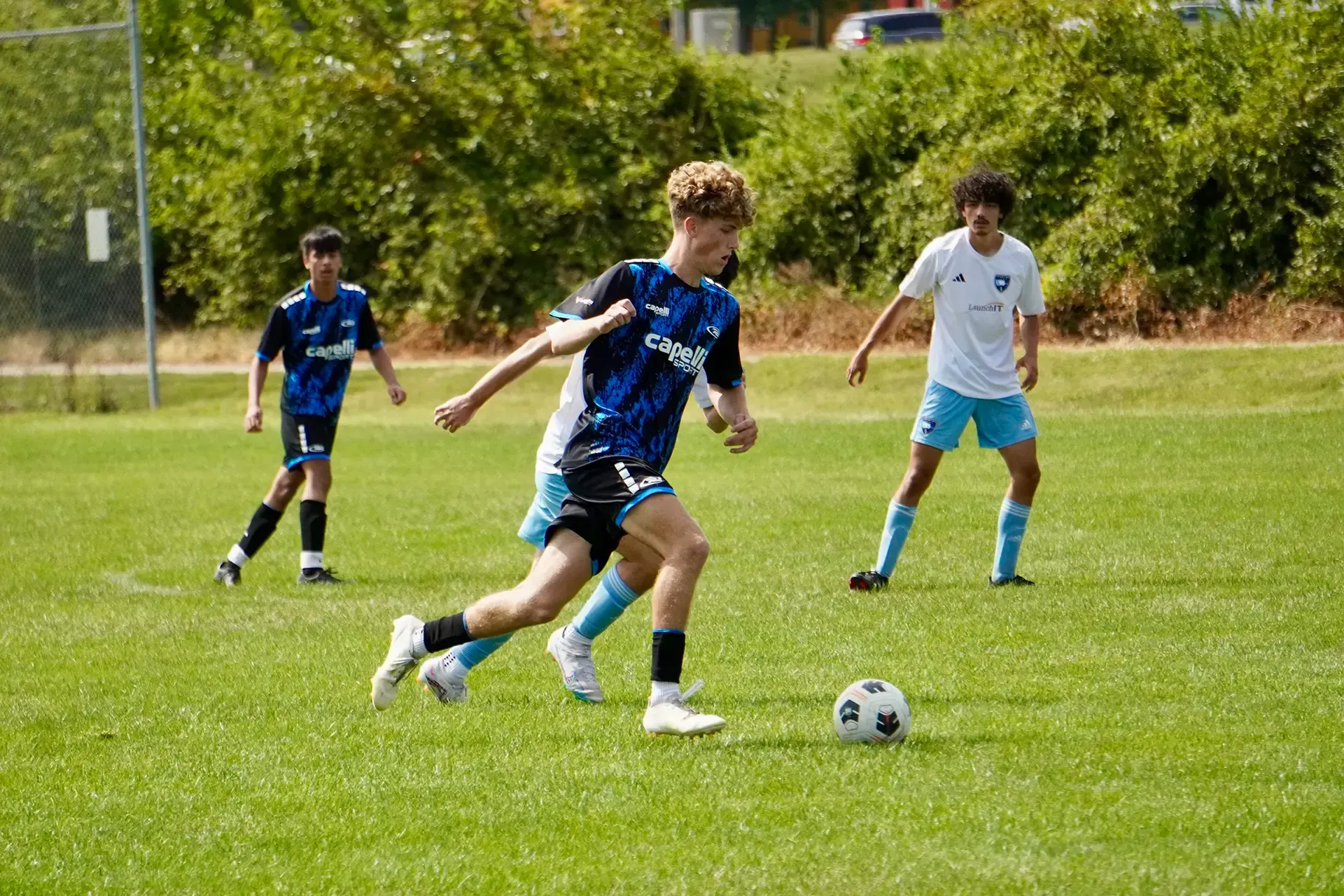 A group of young men are playing soccer on a field.