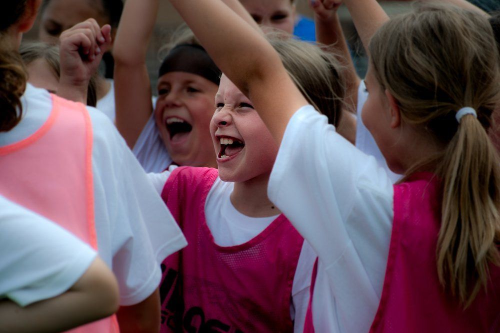 young girl soccer players cheering in a huddle