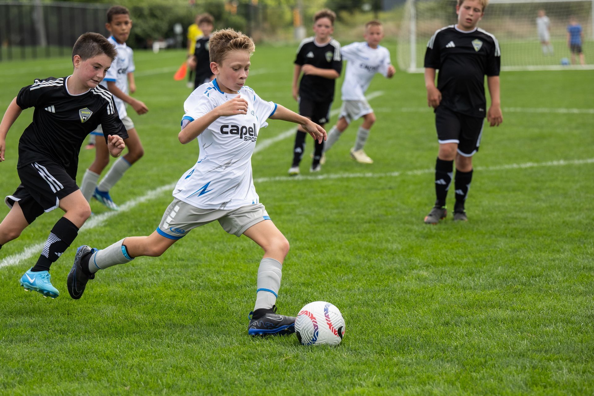 a young boy soccer player kicking the ball